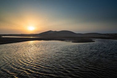 2 Eylül 2019 'da Tatajuba plajı, Camocim, Ceara, Brezilya yakınlarındaki kum tepelerinden ve lagünlerden doğan güneş.