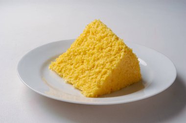Gastronomi. Kuzeydoğu Brezilya 'dan gelen geleneksel mısır kuskusu dilimleri, beyaz bir tabakta.