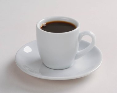 Beyaz arka planda küçük bir fincan kahve.
