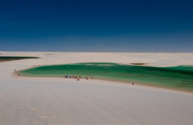 12 Ekim 2006 'da Brezilya' nın Maranhao kentindeki Lencois Maranhenses Ulusal Parkı 'ndaki kum tepecikleriyle çevrili lagünlerdeki turistler. Brezilya 'nın kuzey Atlantik kıyısında doğal güzelliği ve çöl manzarasıyla tanınır.