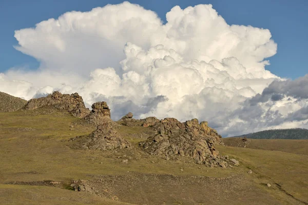 A large cumulus cloud over stone rocks called Suvinsky Castle in the Republic of Buryatia. — Stock Image Large Cumulus Cloud Stone Rocks Called Suvinsky Castle Republic Buryatia Royalty Free Stock Images