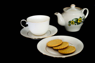 Çay servisi siyah arka planda duruyor.