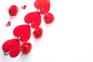dört büyük ve iki küçük kırmızı kalp, ve dört kırmızı yapay gül beyaz arka planda