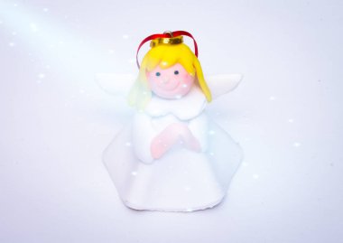 Bir Noel meleği beyaz arka planda bir ışık huzmesinde duruyor., 