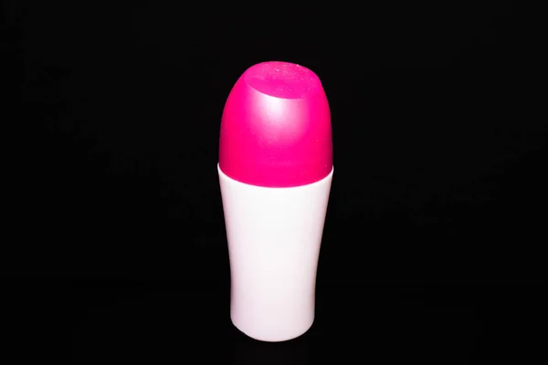 Botol putih dengan tutup pink untuk kosmetik pada latar belakang hitam — Stok Foto