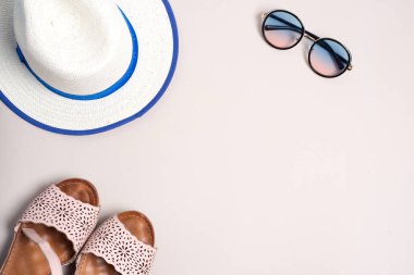 Güneş gözlüğü, sandalet ve bej arka planda bir şapka, plaj için yaz şeyi.