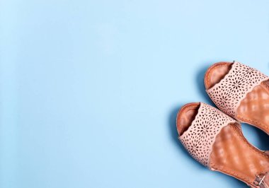 Mavi arka planda kumsal için sandaletler var.