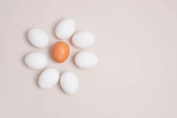 Sedm Bílých Vajec Jedno Hnědé Vejce Formě Květu Béžovém Pozadí — Stock fotografie