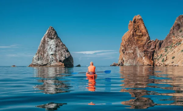 Kayak. Athlete kayaker man enjoys adventure on calm sea with blue water. Leisure activities on the calm blue water. The concept of an active and healthy life in harmony with nature