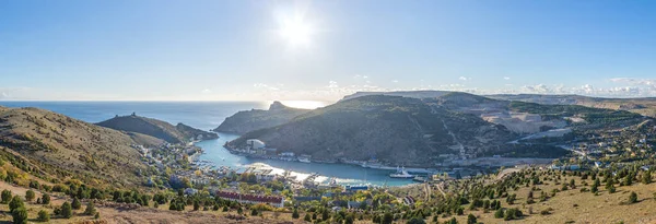 Scenic panoramic view of Balaclava bay with yachts from the ruines of Genoese fortress Chembalo. Balaklava, Sevastopol, Crimea. Inspirational travel landscape. Aerial photo. Copy space