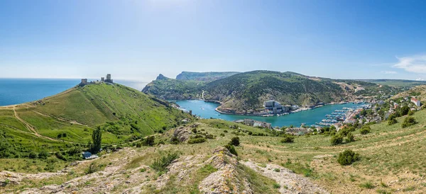 Scenic panoramic view of Balaclava bay with yachts from the ruines of Genoese fortress Chembalo. Balaklava, Sevastopol, Crimea. Inspirational travel landscape. Aerial photo. Copy space.