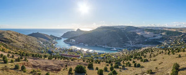 Scenic panoramic view of Balaclava bay with yachts from the ruines of Genoese fortress Chembalo. Balaklava, Sevastopol, Crimea. Inspirational travel landscape. Aerial photo. Copy space