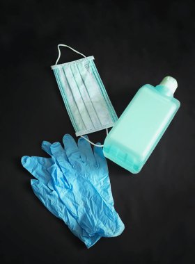Mavi steril lastik eldiven, büyük bir şişe antiseptik ve steril maske.