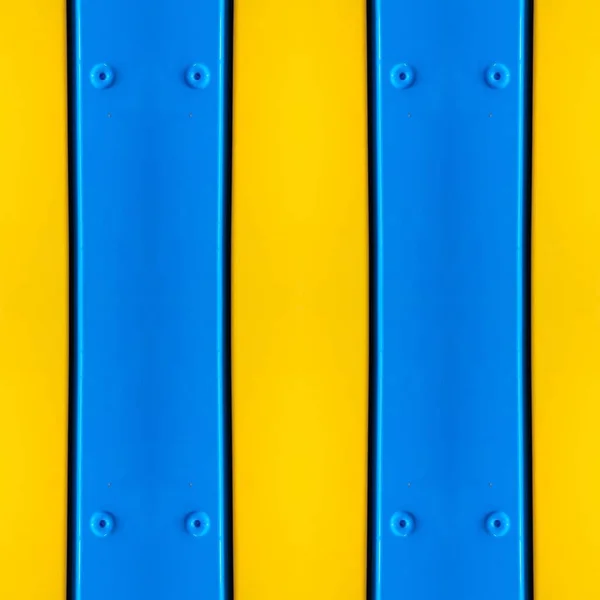 bright blue painted metal with rivets against vivid sunshine yellow background