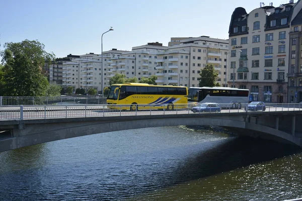 Stockholm, İsveç. 25 Temmuz 2014. Sarı ve mavi turistik otobüsler boğazdaki köprüden geçiyor..