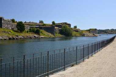 Sveaborg, Finlandiya. 24 Temmuz 2014. İsveç ve Rus askerlerinin inşa ettiği ortaçağ kalesi ve adalar arasındaki boğaza bakın. Ön planda kumlu kaldırım ve metal korkuluklar.