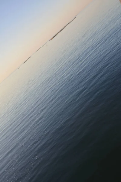 Стокгольмський архіпелаг, Швеція. 25 липня 2014. Захід сонця в Балтійському морі. Спокійна вода з градієнтними кольоровими брижами. — стокове фото