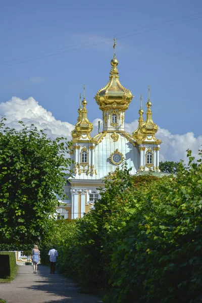 Peterhof, Sankt Petersburg, Russland. 18. Juli 2014. Zerkownij Korpus Bolschogo Dworza Peterhof Großen Palast. Kirchengebäude mit goldener Kuppel und Kuppel mit orthodoxem Kreuz in der Spitze, umgeben von — Stockfoto