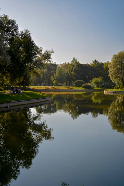 Mirror reflection of a park in calm lake waterin summer — Stock Photo, Image