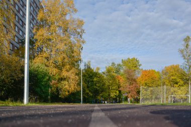 Okul stadyumundaki koşu yolu altın yeşili park alanına çıkıyor.