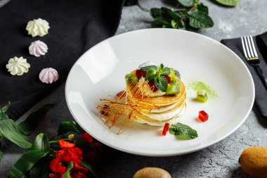 Gri mavi tabakta kremalı börek yığını.