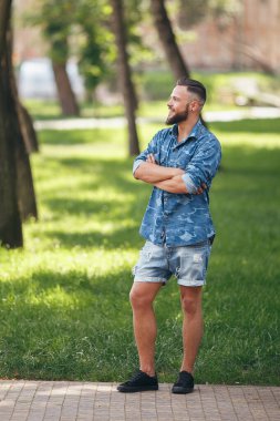 Bahar parkında yürüyen genç adam. Güneşli bir gün. Vesna. Komik adam. İyi bir ruh hali. Yürüyen portre.