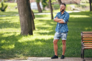 Bahar parkında yürüyen genç adam. Güneşli bir gün. Vesna. Komik adam. İyi bir ruh hali. Yürüyen portre.