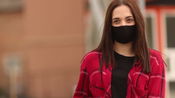 Vrouw, meisje zet chirurgisch masker op voor corona viruspreventie. Portret van een meisje met een masker op straat. Masker op straat. — Stockvideo