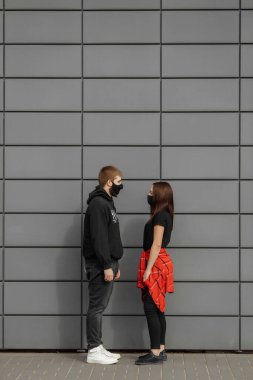 Birbirine aşık bir çift, koruyucu maskeli kadın ve erkek sokakta yüz yüze. Karantina bölgesi. Guy, kız dünya pandemik koronavirüse karşı, virüs koruması