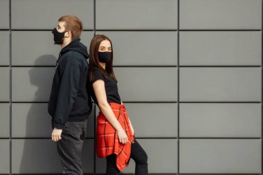 Birbirine aşık bir çift, koruyucu maskeli kadın ve erkek sokakta yüz yüze. Karantina bölgesi. Guy, kız dünya pandemik koronavirüse karşı, virüs koruması