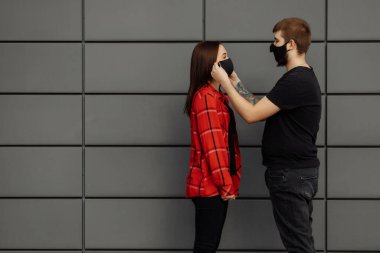 Kız adama koruyucu bir maske takıyor.