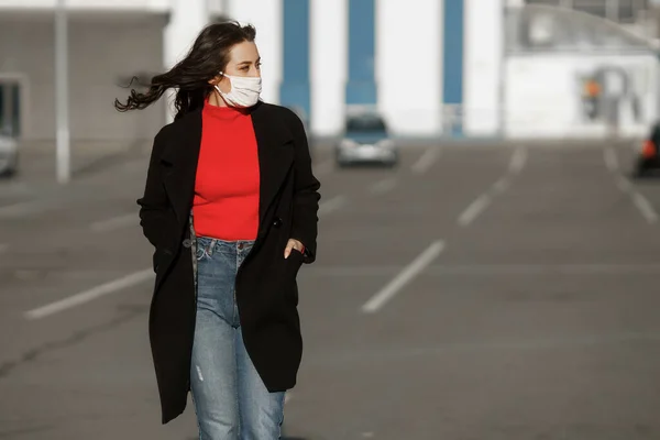 Uma menina mascarada está andando pela rua. Infecção pelo vírus da coronária COVID-19 — Fotografia de Stock