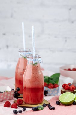 Hafif bir arka planda saman ve nane aromalı bir şişede ahududu püresi..