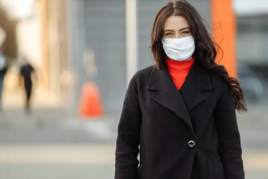 Bulaşıcı hastalıklara karşı korunmak için koruyucu maske takan güzel bir kadının portresi. Grip kapmış çekici, mutsuz bir model.