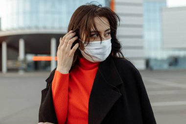 Bulaşıcı hastalıklara karşı korunmak için koruyucu maske takan güzel bir kadının portresi. Grip kapmış çekici, mutsuz bir model.