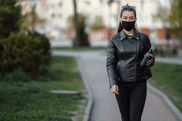 Una chica enmascarada camina por la calle. Infección por Coronavirus COVID-19 — Foto de Stock