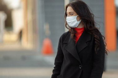 Bulaşıcı hastalıklara karşı korunmak için koruyucu maske takan güzel bir kadının portresi. Grip kapmış çekici, mutsuz bir model.