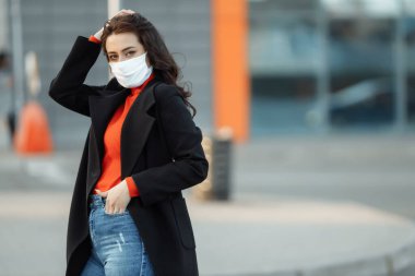 Bulaşıcı hastalıklara karşı korunmak için koruyucu maske takan güzel bir kadının portresi. Grip kapmış çekici, mutsuz bir model.