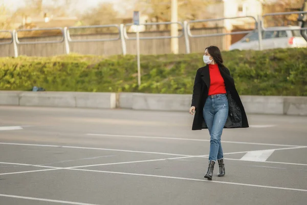 En maskerad flicka går längs gatan. Coronavirusinfektion COVID-19 — Stockfoto