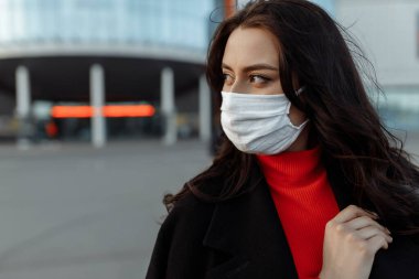 Sokakta koruyucu maske takmış güzel bir kadının portresi.