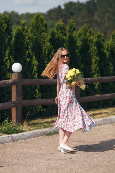 Ritratto tranquillo di una bella ragazza in piedi con un bouquet in primavera . — Foto Stock