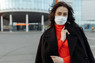 Bulaşıcı hastalıklara karşı korunmak için koruyucu maske takan güzel bir kadının portresi. Grip kapmış çekici, mutsuz bir model..