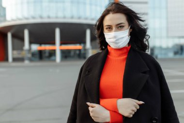 Bulaşıcı hastalıklara karşı korunmak için koruyucu maske takan güzel bir kadının portresi. Grip kapmış çekici, mutsuz bir model..