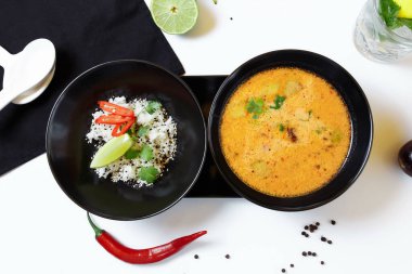 Tom Kha. Baharatlı Asya çorbası, patlıcan, tavuk, mantar, limon otu, pirinç ve kişniş ile servis edilir..