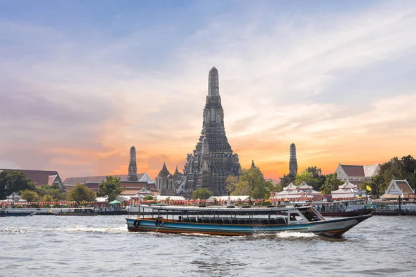 El Templo de Dawn, Wat Arun, en el río Chao Phraya con barcos de pasajeros o barco y un hermoso cielo en el crepúsculo en Bangkok, Tailandia —  Fotos de Stock
