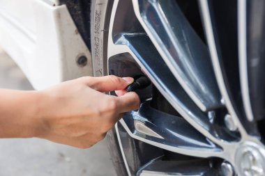 Adam hava basıncı ve dolum havada araba lastikleri kontrol etmek. Kavram resmi