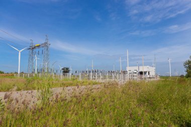elektrik direkleri ve santral veya rüzgar türbini açık doğada istasyonla