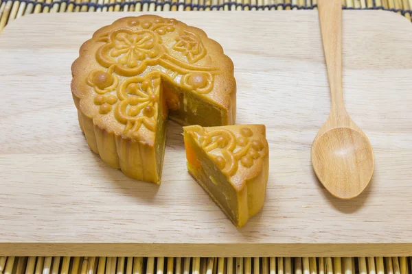 Bolo da lua do Festival do Meio-Outono na mesa de madeira com colher — Fotografia de Stock