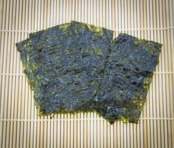 Крупним планом запечена морська водорості закуска на традиційному бамбуковому килимку — стокове фото