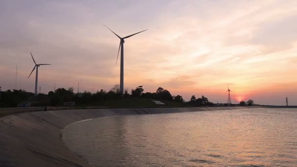 Aerogeneradores que crean energía verde con depósito al atardecer — Vídeo de stock